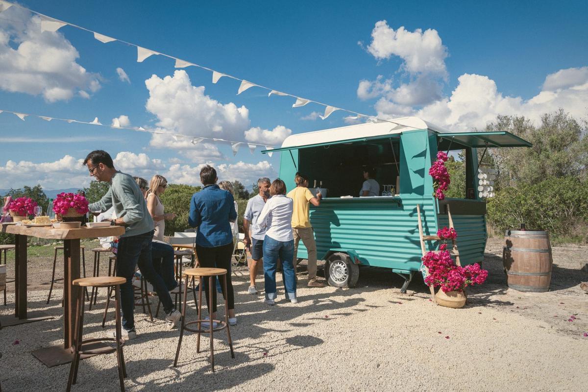 Festival-goers at a food truck under bunting