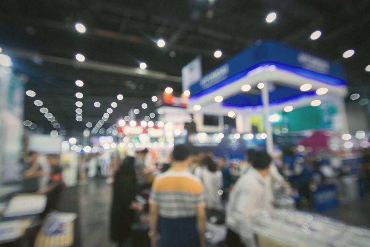 Visitors walking through a busy exhibition hall